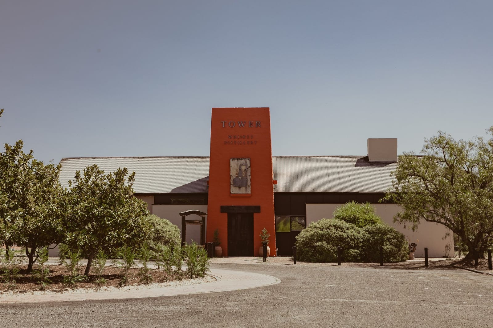 Distillery with red tower, white walls and trees at Tower Whiskey Distillery, Pokolbin, Hunter Valley