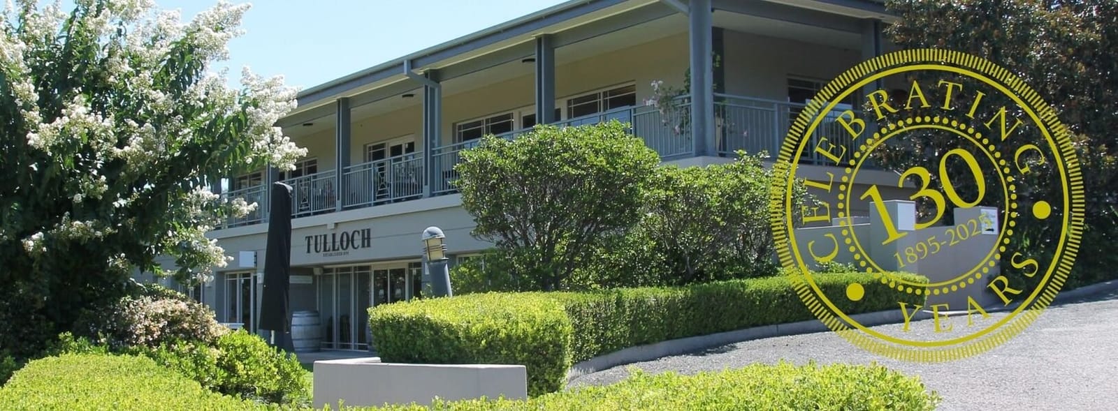 Cellar door with landscaped hedges and anniversary branding at Tulloch, Pokolbin, Hunter Valley