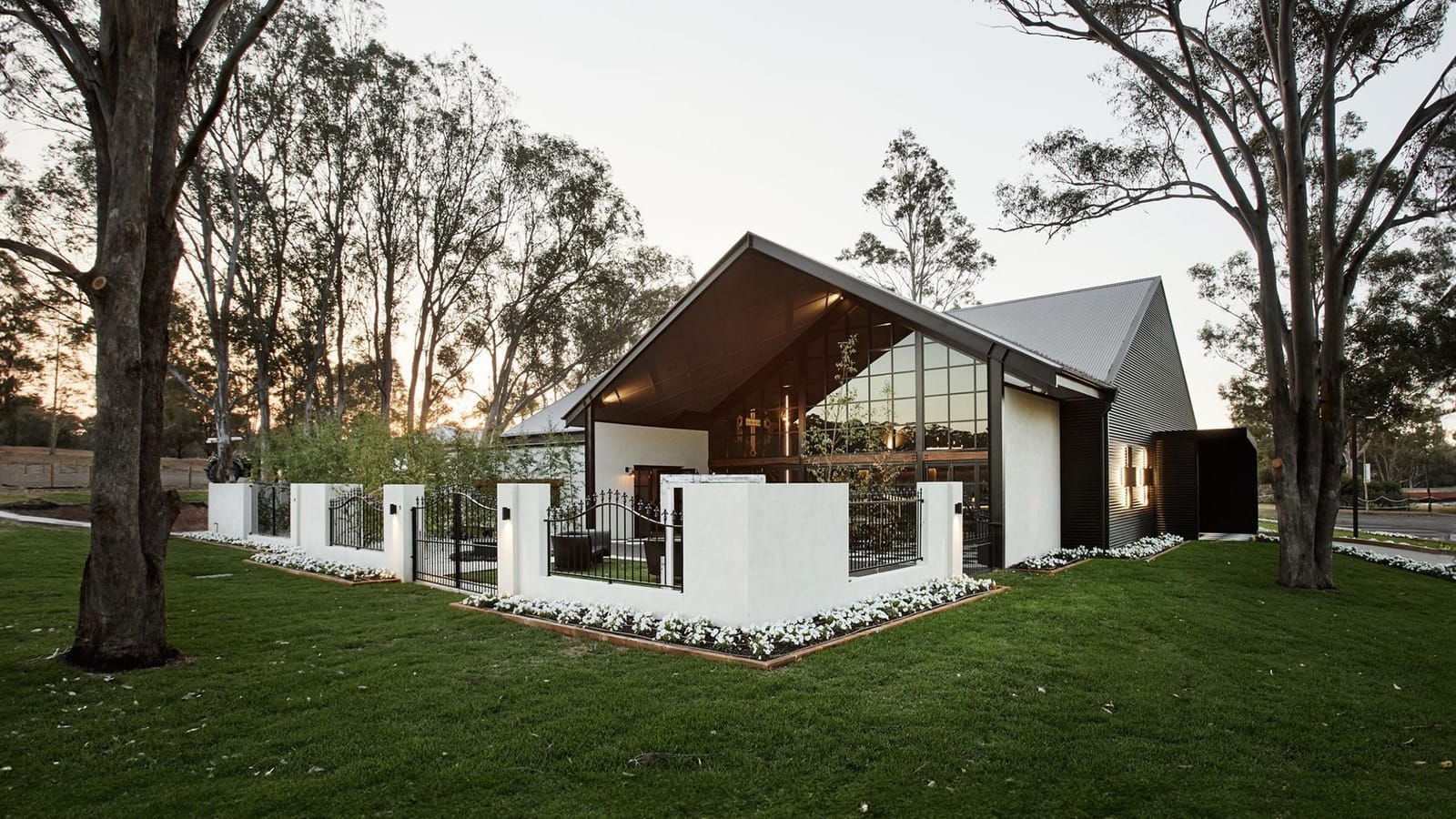 Modern tasting room building set among tall eucalyptus trees on manicured lawns