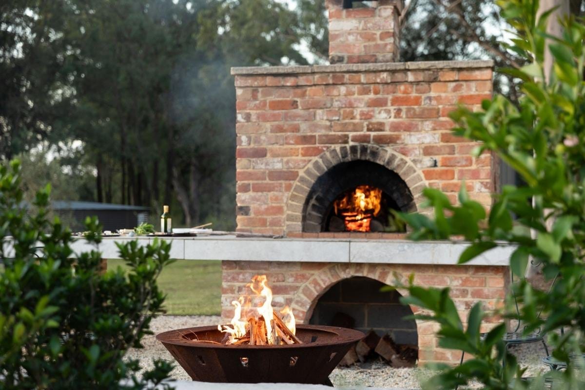 Outdoor brick fireplace and wood-fired oven for entertaining guests