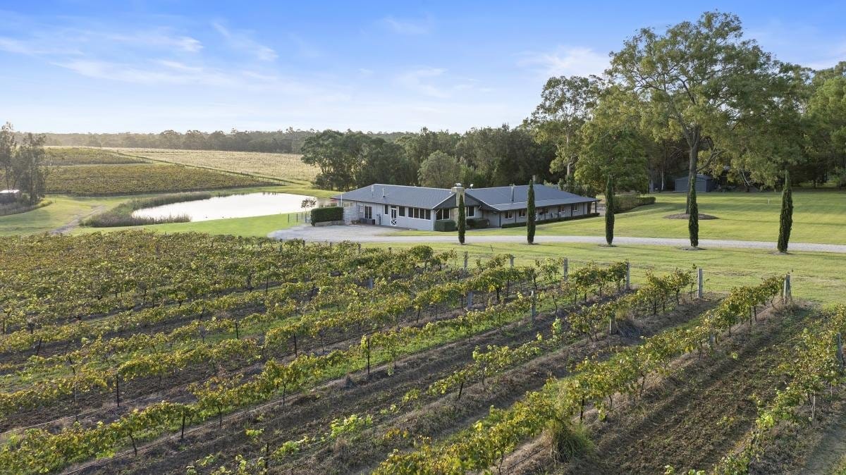 Modern lodge building set in gardens and vineyards with central pond at Vico Monti Estate, Pokolbin, Hunter Valley