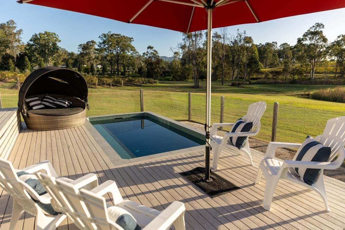 Swimming pool and lounge area on wooden deck overlooking vineyards