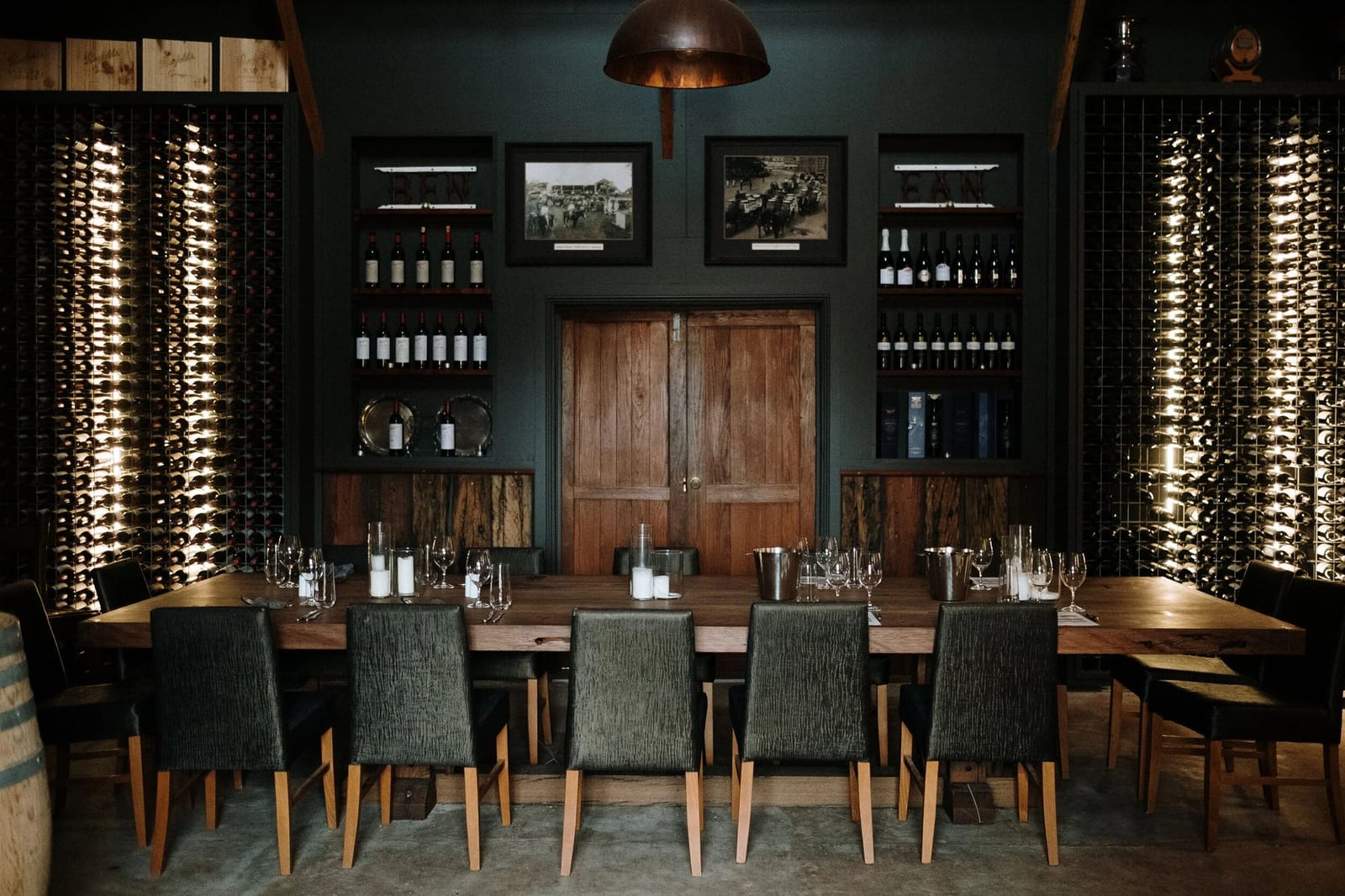 Long tasting table set with glasses in historic cellar with bottle-racked walls at Weerona, Pokolbin, Hunter Valley