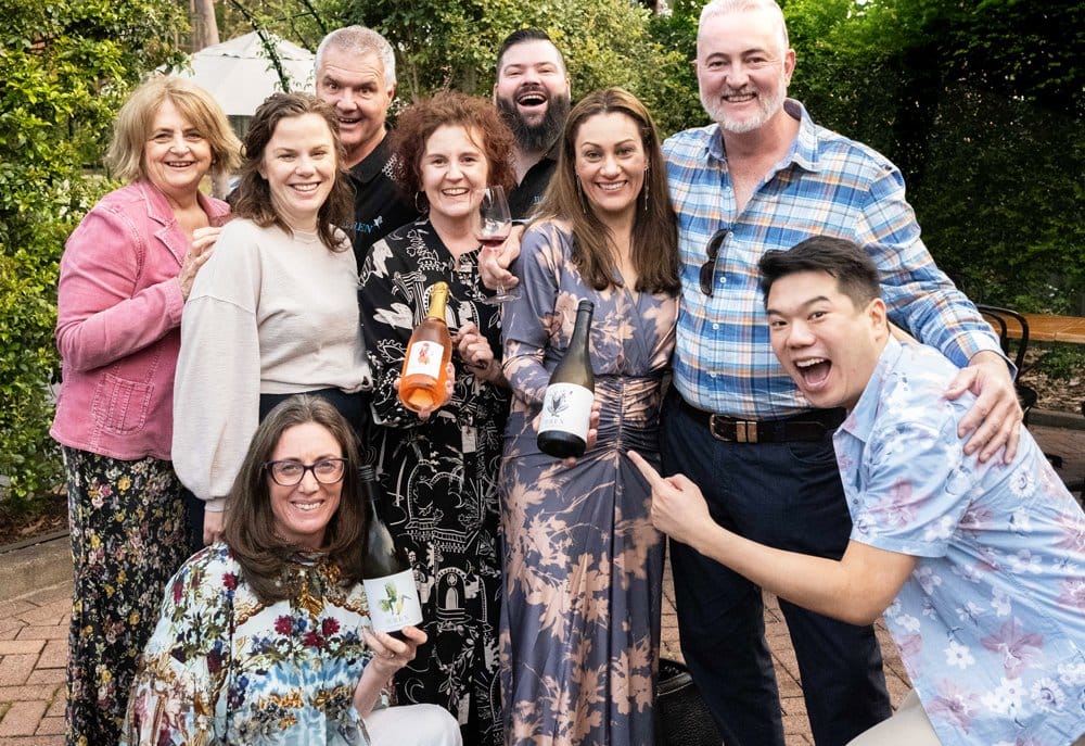 A group of guests holding Wren bottles at a wine event