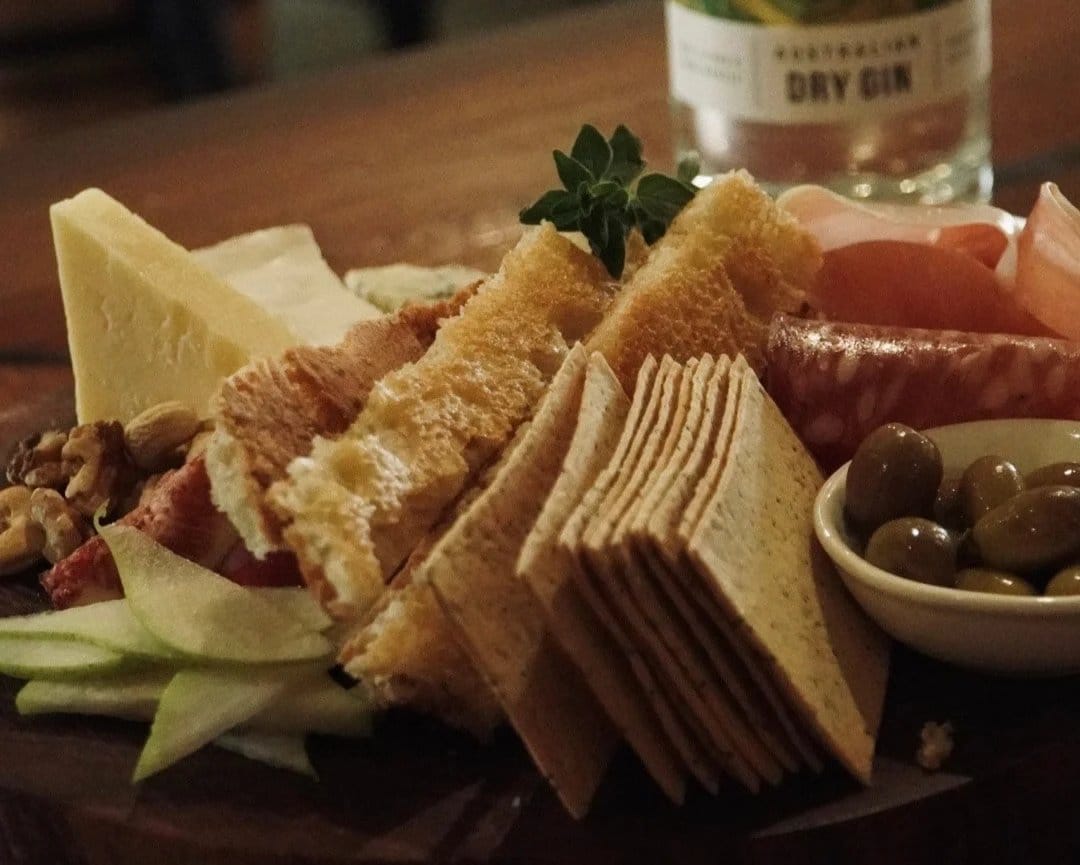 Cheese and charcuterie board with crackers and olives served at Wildstreak Kitchen