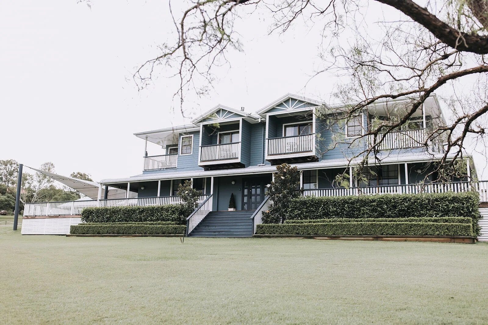 Two-storey Hamptons-style house seen across front lawn at Willow Tree Estate, Pokolbin, Hunter Valley