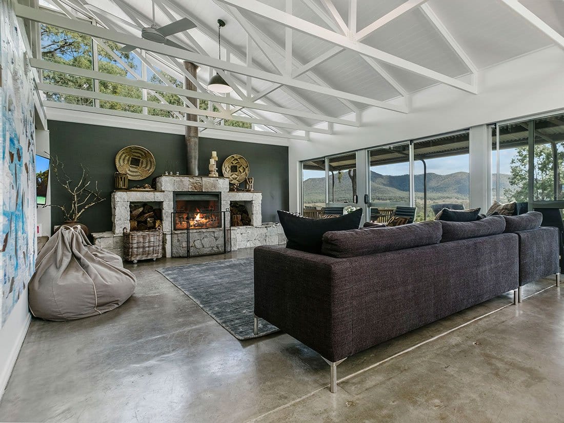 Modern lounge with sofa, fireplace and views across vineyards