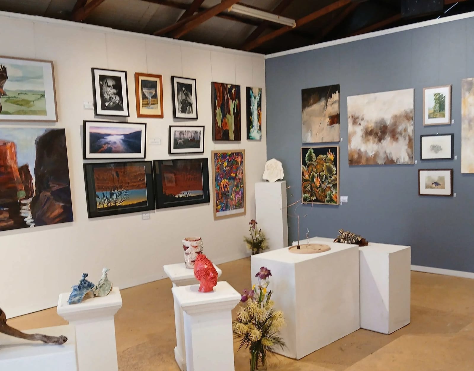 Art and craft gallery with wall-mounted artworks and sculptures on display