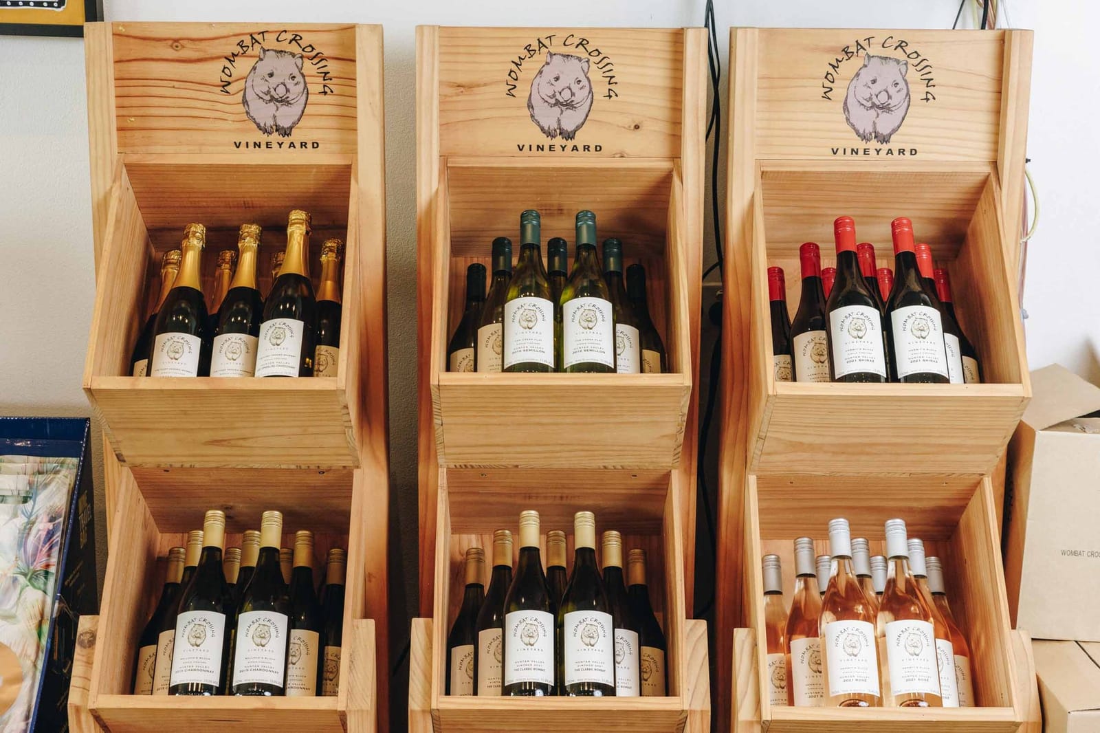 Wombat Crossing bottles stacked in branded timber crates at the cellar door